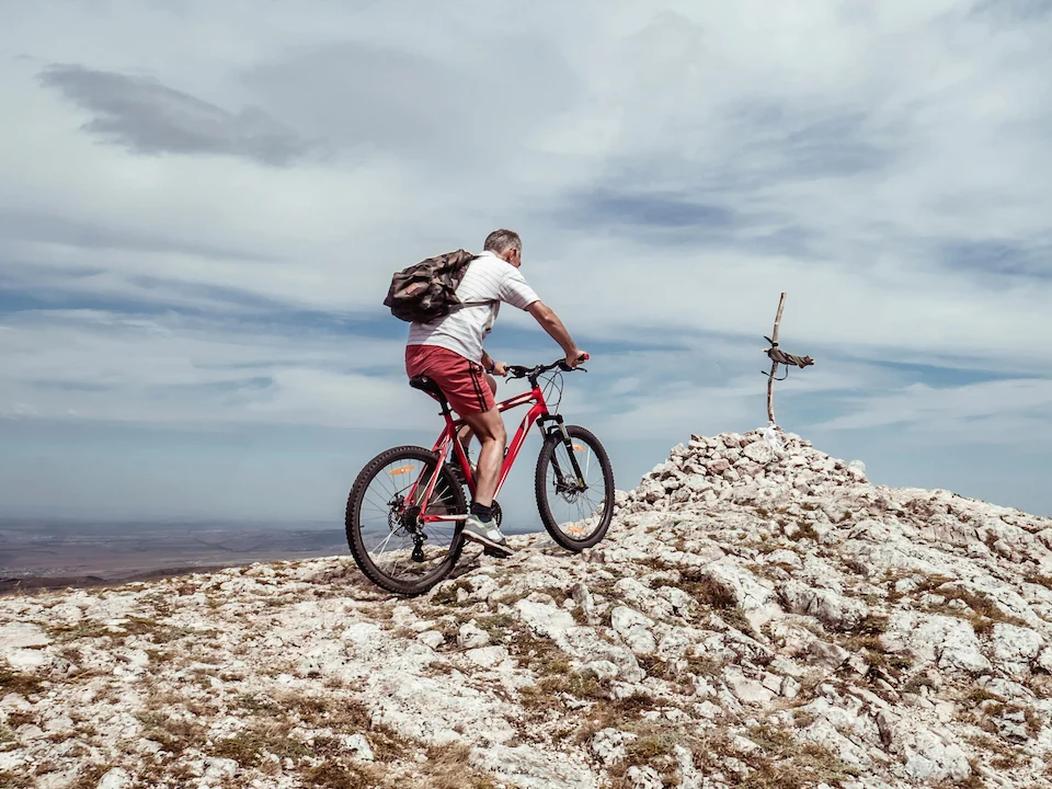 ciclista mirando la sierra con cicicleta a su lado